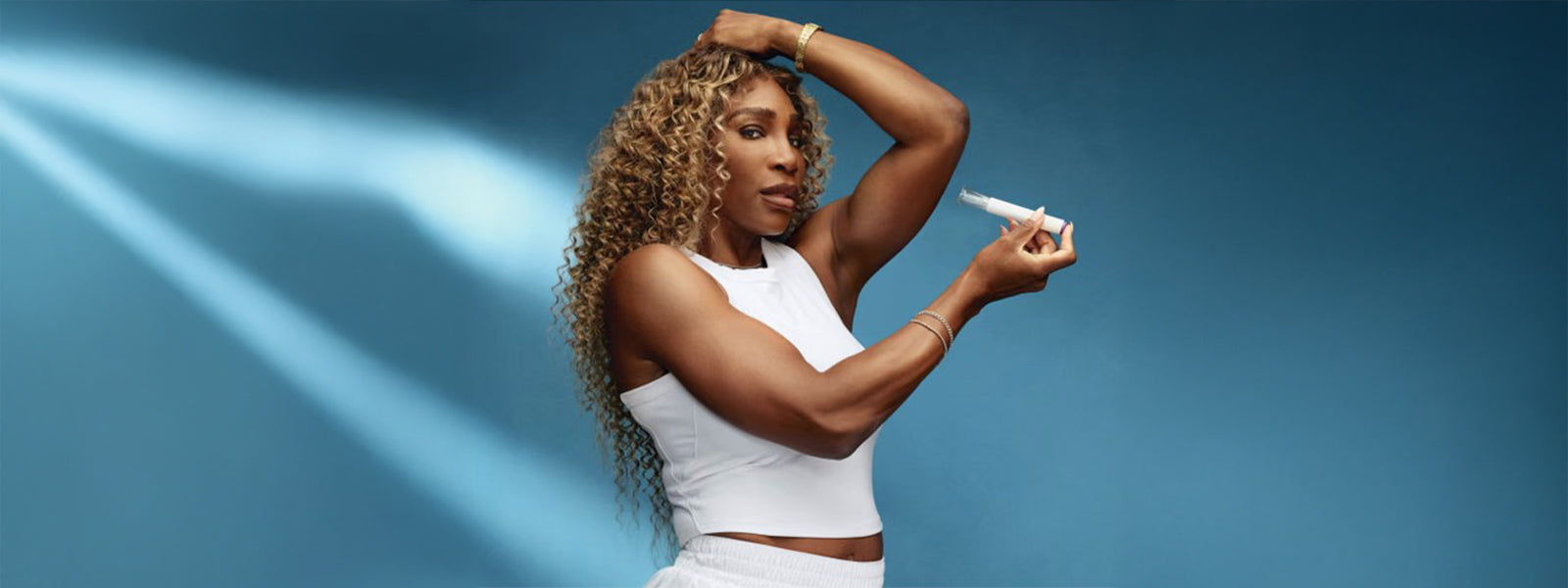 Serena Williams promoting GLP-1 weight loss treatment in Ro campaign, holding injector pen against her arm while wearing a white crop top.